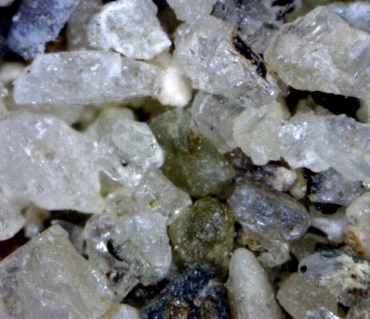 Quartz and rock fragments from a glacial stream deposit near Osoyoos, B.C. The grains are between 0.25 and 0.5 mm across. [SE]
