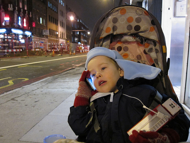 A young child talking on the phone.