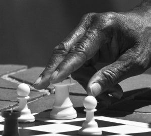 A chess player with his hand on a rook.
