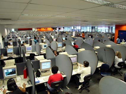 Many people at workstations in a call centre.