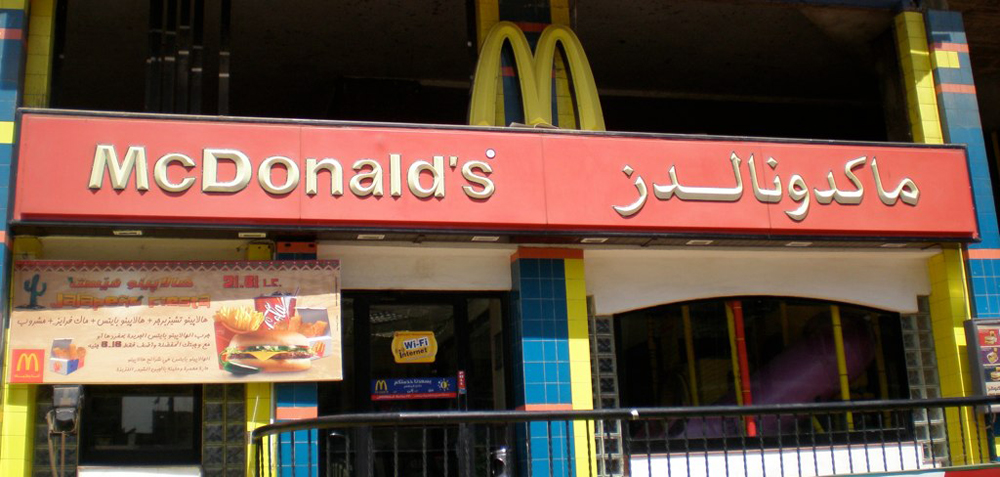 A McDonald's storefront in Egypt with its name in English and Arabic.